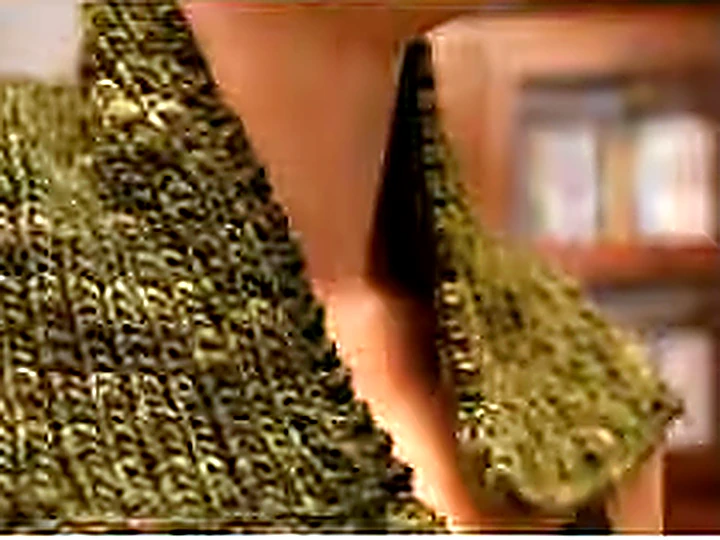 A hand-knit olive cable panel held in two hands.
