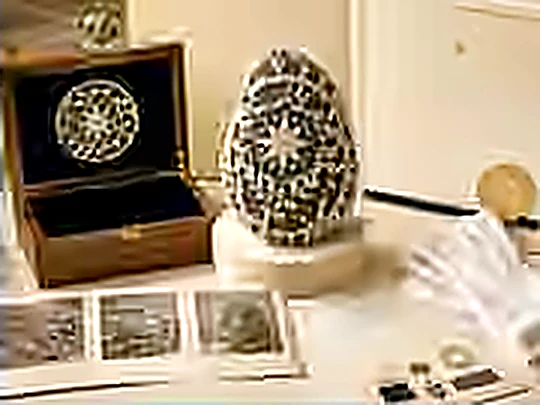 A crocheted stone presented in a lined box.