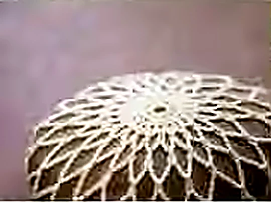 A large white crocheted doily worked in fine cotton thread.