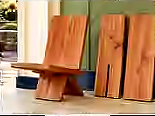 Three flat-pack plank chairs, one assembled and two folded flat.